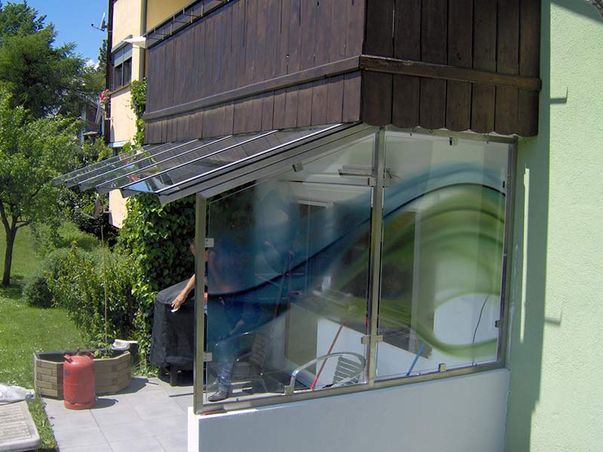 Vordach aus Glas und Windschutz